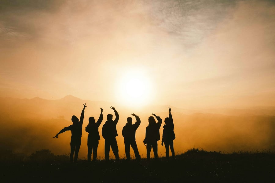 A group of silhouetted people at sunset